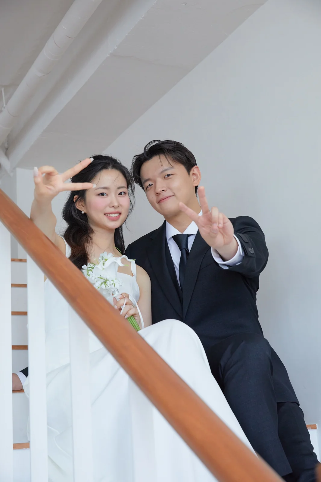 계단에서 브이 포즈를 취한 두 사람