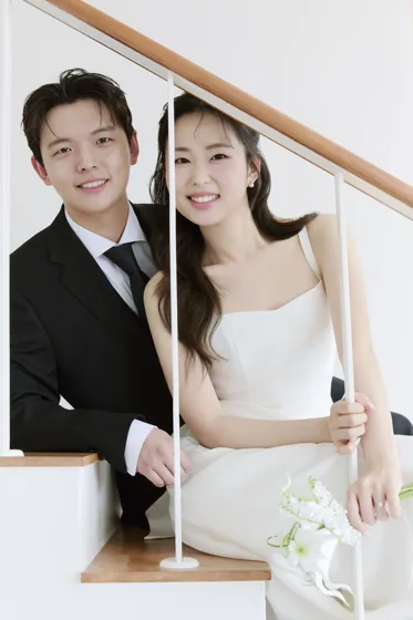 계단 난간 사이로 함께 웃는 두 사람