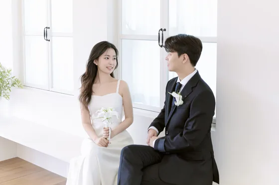 창가에 앉아 서로 바라보는 두 사람