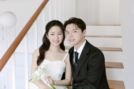 계단에 나란히 앉아 웃는 두 사람